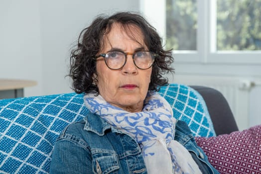 portrait of a beautiful brunette senior woman on the sofa