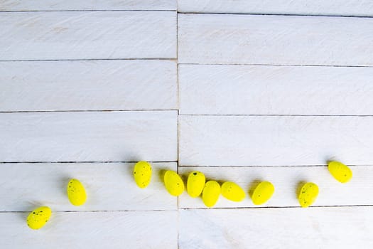 Easter concept. Yellow eggs stand on a white wooden table.