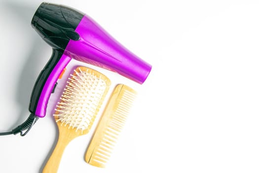 Professional hairdresser's set on white background, top view. Hairdryer, hair brushes, combs.