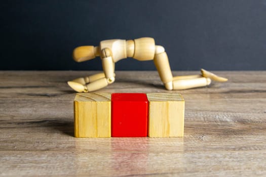 The concept of sadness, satomy, man became disillusioned with himself - wooden mannequin with surreal wood cube isolated on white background.