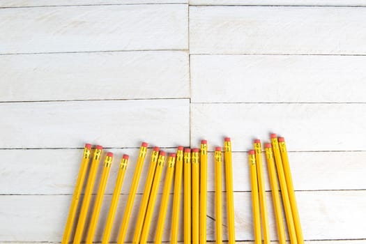 A set of orange pencils on a white wooden table. Printing supplies.