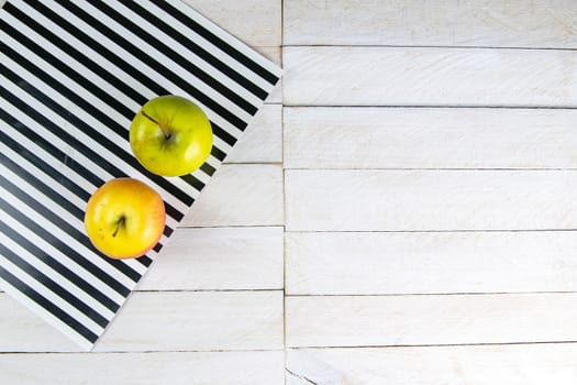 Two apple on white wooden garden or park table.