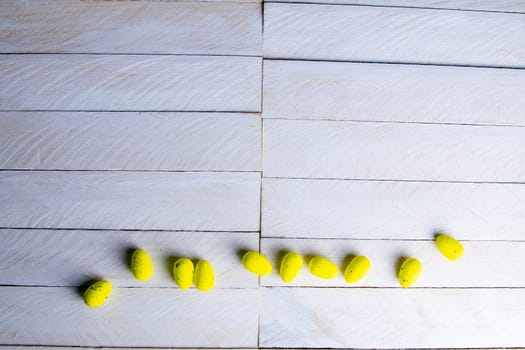 Easter concept. Yellow eggs stand on a white wooden table.