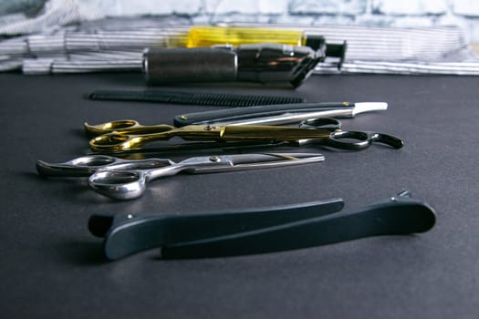 Hairdressing tools, scissors, hair clipper, comb, dangerous razor, hair gel stand on black background.
