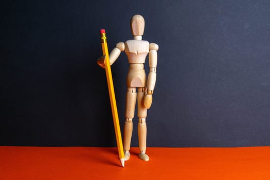 The figure of a wooden man holds pencil. Front views.