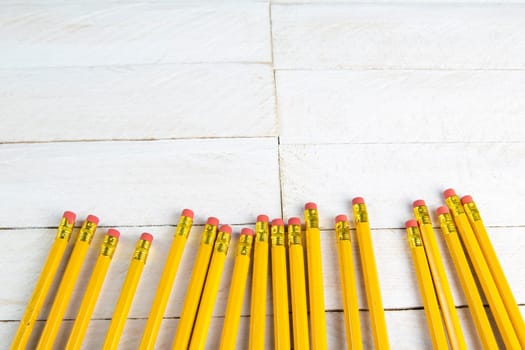 A set of orange pencils on a white wooden table. Printing supplies.