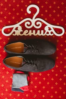 The groom's shoes and socks on the carpet