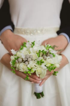 Elegant bride and groom posing together in studio on a wedding day