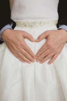 Elegant bride and groom posing together in studio on a wedding day