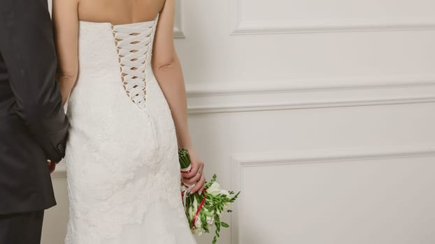 Elegant bride and groom posing together in studio on a wedding day
