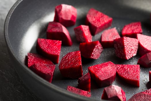 Cut beetroot in pan for cooking.