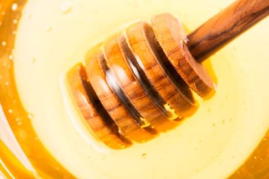 Close up of honey dipper in honey jar.