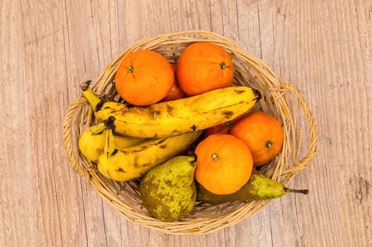 Healthy food. Organic fruits and vegetables, bananas, clementines, pears on a wooden background