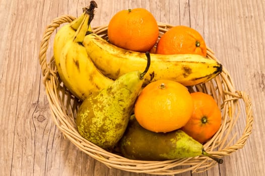 Healthy food. Organic fruits and vegetables, bananas, clementines, pears on a wooden background