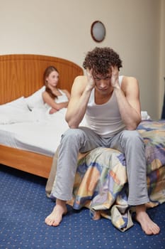 Family problems. Young couple quarrels in bedroom at home. Family conflict. Selective focus on man