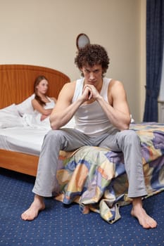 Family problems. Young couple quarrels in bedroom at home. Family conflict. Selective focus on man