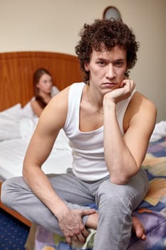 Family problems. Young couple quarrels in bedroom at home. Family conflict. Selective focus on man