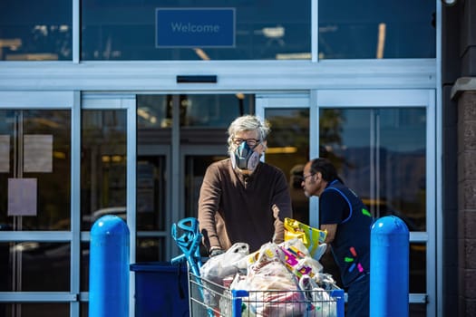 TUCSON, UNITED STATES  - March 29: Unidentified man wearing a ventilator mask leaving a retail store with groceries during the coronavirus pandemic. March 29, 2020 in Tucson, Arizona, USA.