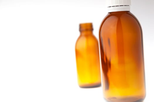 Selective focus two medicine bottles close up isolated on white background.