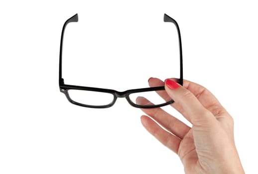 Female hand holding a black-framed glasses isolated on white background