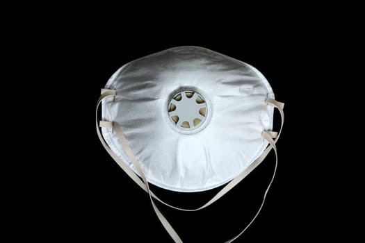 White Surgical Mask FFP2 To Protect Against Virus Infection Coronavirus COVID-19, Isolated On Black Background, Close Up View