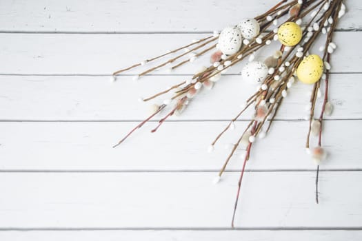 Easter decorations. Willow twigs and decorative Eggs on white wooden background. Copyspace