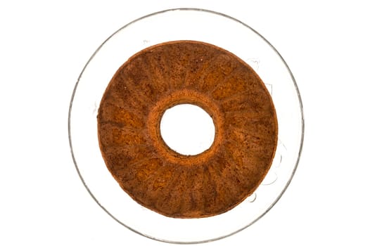 Circular marbled cake laying on a glass tray top view on a white background