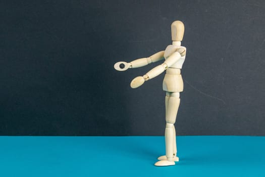 The figure of a wooden man stretches his arms forward, he wants to hug someone. The concept of loneliness, the need for attention. Close-up