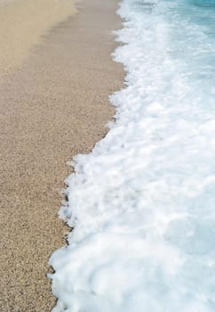 sand beach and blue wave sea with white foam