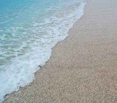 sand beach and blue wave sea with white foam