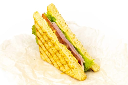 Sandwich with ham, cheese, tomatoes, lettuce, and toasted bread. Front view isolated on white background.