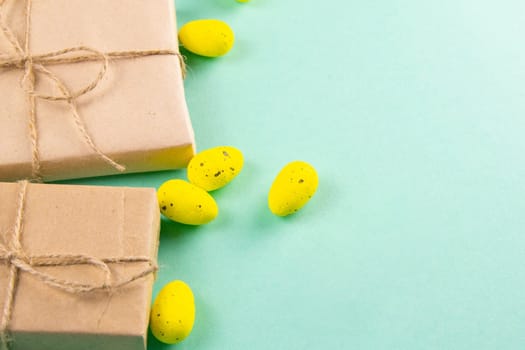 Two easter gifts, yellow eggs on a mint background close-up. Easter background.