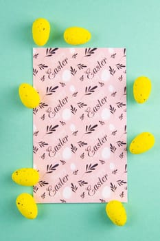 Easter card with yellow eggs on a mint background close-up. Easter background.