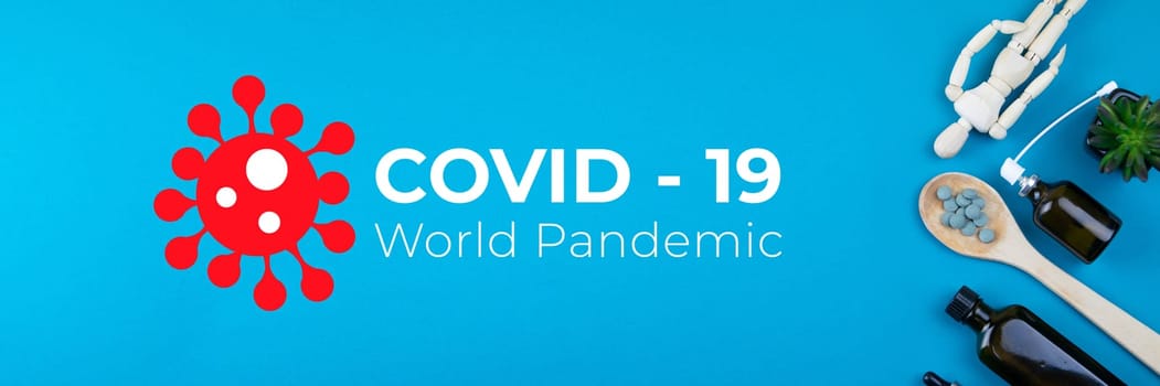 Wooden toy figure with pills on a spoon on blue background. Various capsules, tablets and medicine against Covid-19 World pandemic.