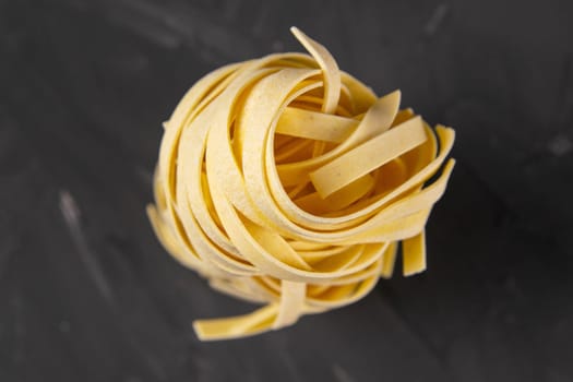column raw dry nest pasta with reflection isolated on black. Top views