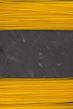 Yellow long spaghetti on a dark background. Top views with clear space