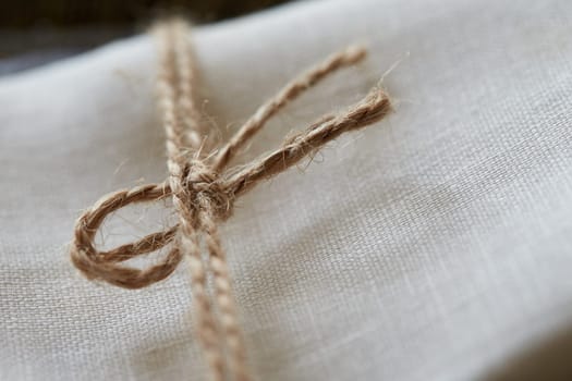 Twine tied in a bow. Close-up. Fabric background