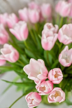 Decor and a vase with pink tulips on a table. Selective focus.
