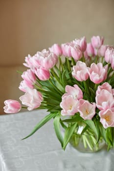 Decor and a vase with pink tulips on a table. Selective focus.