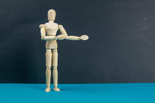 Wooden mannequin on black table and blue background. trun right concept. Close-up