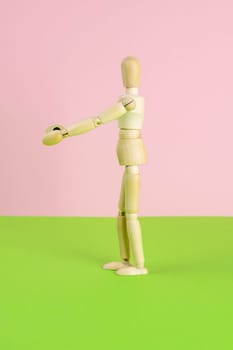 The figure of a wooden man stretches his arms forward, he wants to hug someone. The concept of loneliness, the need for attention. Close-up