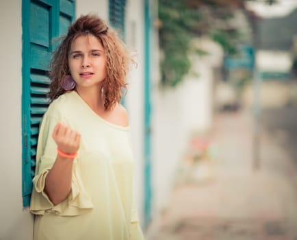 Outdoor portrait of a beautiful woman next to shutter window