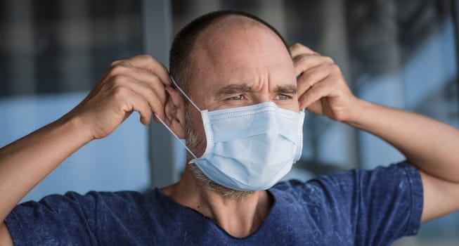 Man wearing facial disposable mask to avoid viral infection. Virus protection