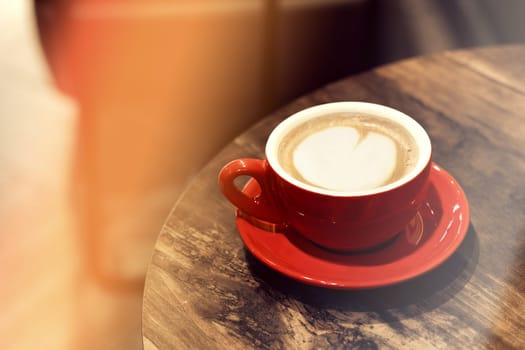 cappuccino cup on the brown wooden table in a cafe