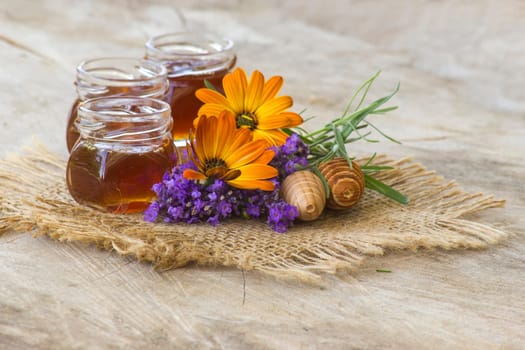 honey and flowers on wooden  background