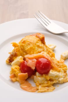 Scrambled eggs with tomatoes salmon and feta cheese in vertical format