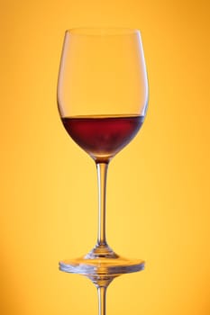Sweet dessert wine in a glass in yellow back lit vertical format