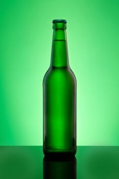 Green beer bottle with crown cap in vertical format in back lit