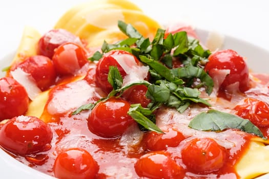 Cherry tomatoes tomato sauce with basil and parmesan on tortellini pasta