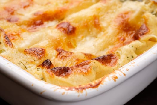 Pasta Cannelloni filled and gratinated with cheese as close-up